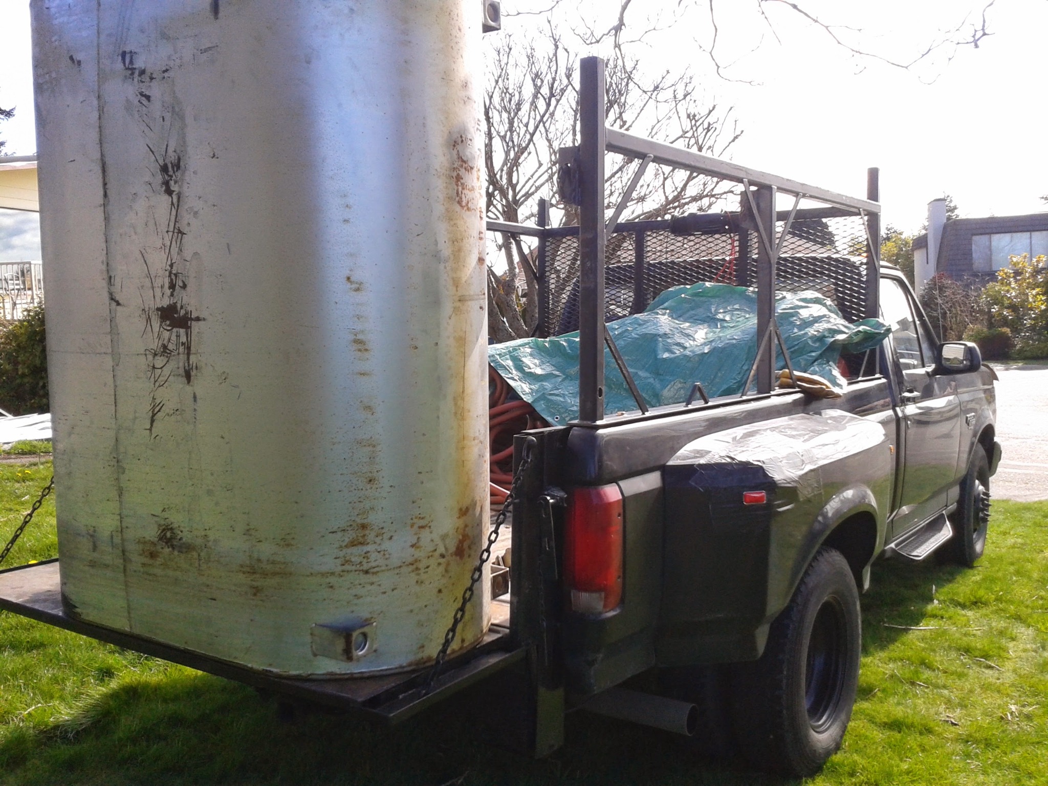 Island Tank transporting an oil tank for removal